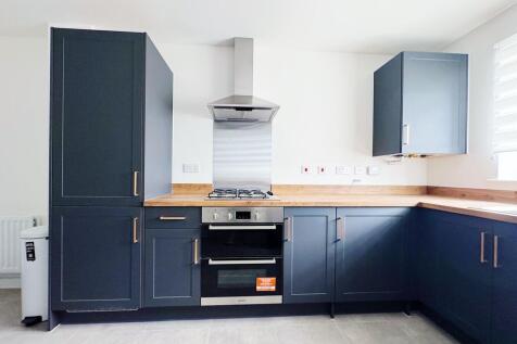 Modern fitted kitchen with navy shaker cabinets...