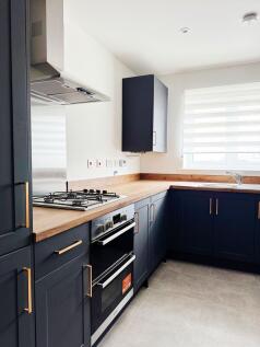 Bright, modern kitchen with navy shaker cabinet...