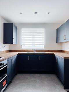 Modern U-shaped kitchen with dark navy cabinetr...