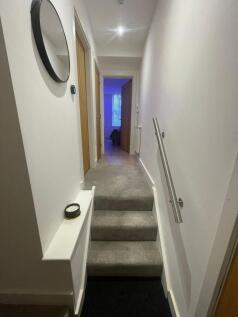 Bright, well-maintained hallway with carpeted s...