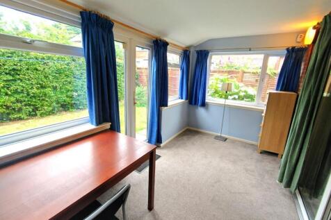 Bright, carpeted workspace with large windows a...