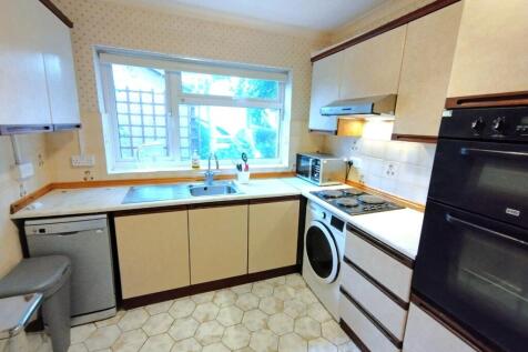 Bright galley-style kitchen with a large window...