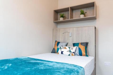 Bright, neatly styled bedroom with a comfortabl...