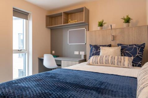 Bright, neatly furnished bedroom featuring a co...