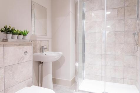 Bright, modern bathroom with large tiled shower...