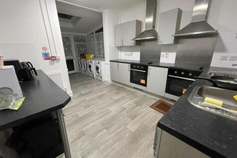 Modern shared kitchen with built-in ovens, stai...