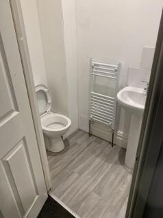 Compact, freshly painted restroom with a pedest...