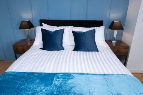 Bright, neatly styled bedroom featuring a doubl...