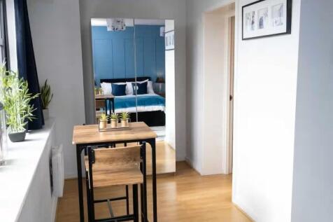 Bright, modern bedroom with a mirrored wardrobe...