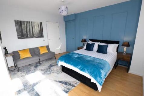 Bright, modern master bedroom with a comfortabl...