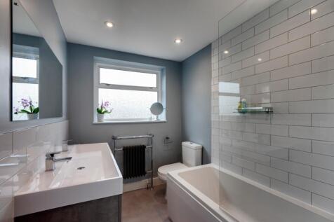 Modern bathroom with a white bathtub, large rec...