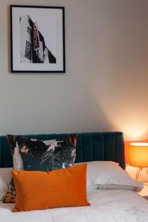 Stylish double bedroom with a plush teal uphols...