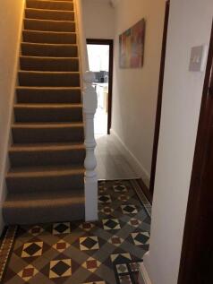 Welcoming hallway with patterned tiled flooring...