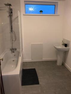 Bright modern bathroom with a full bathtub and ...