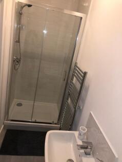 Bright, modern bathroom with a fully tiled show...