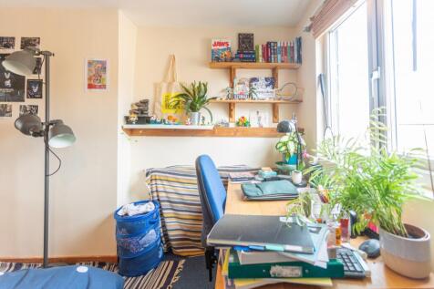 A cozy communal workspace featuring ample natur...