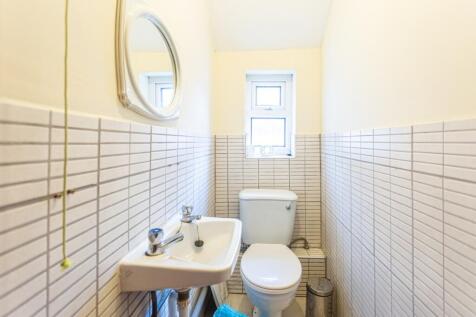 This cozy single toilet features a clean and ti...
