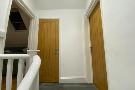 A clean and bright hallway leading to private r...