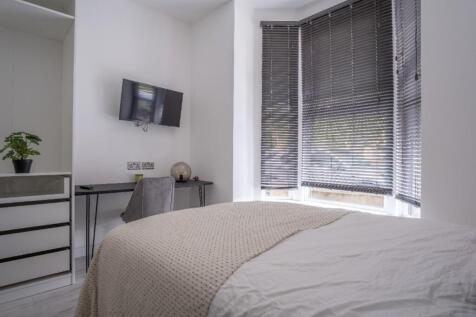 This inviting double bedroom features a comfort...
