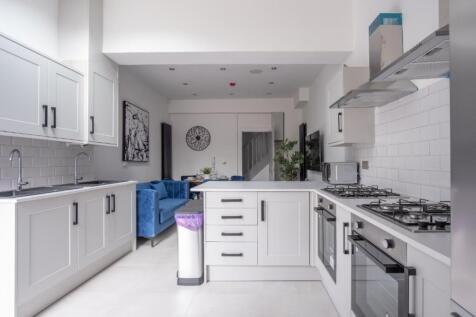 Spacious and modern kitchen featuring sleek cab...