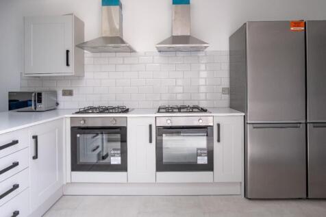 A modern kitchen featuring sleek white cabinetr...