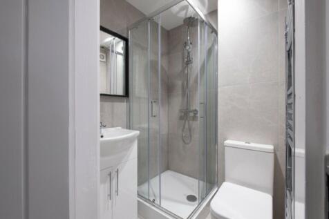 Modern bathroom suite featuring a sleek glass s...