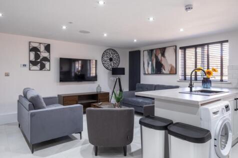 A stylish and contemporary living room featurin...