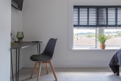 A stylish double bedroom featuring a cozy desk ...