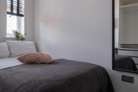 This charming double bedroom features a cozy at...