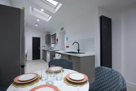 A modern kitchen featuring sleek cabinetry, a s...