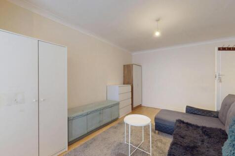 A tidy and neutral-toned living room featuring ...