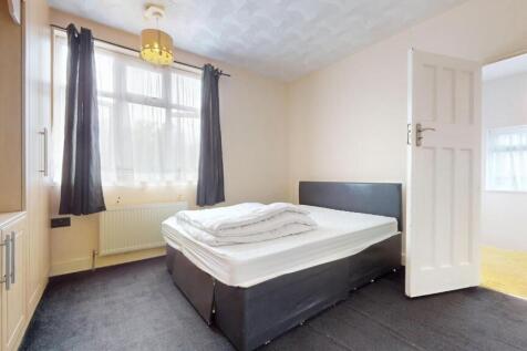 A bright double bedroom featuring a comfortable...