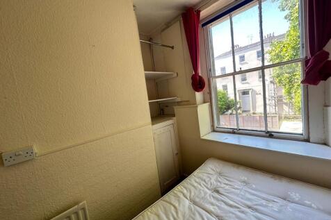 A cozy double bedroom featuring a large window ...