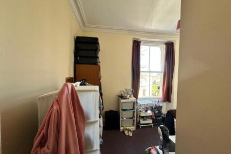A cozy double bedroom featuring a good-sized wi...