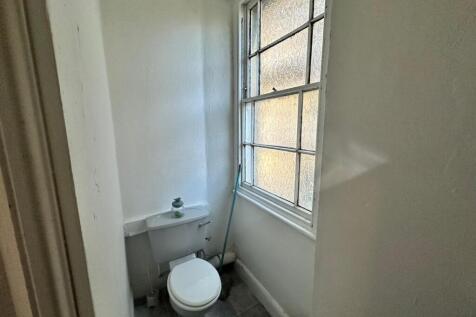 A bright and tidy single toilet with natural li...