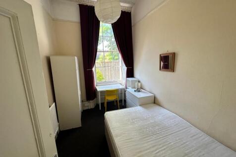 A bright and inviting double bedroom with a des...