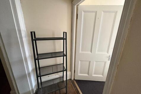 A tidy hallway with storage space, providing a ...