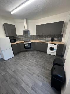 Modern kitchen featuring sleek grey cabinets wi...