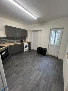 A modern kitchen featuring sleek dark grey cabi...