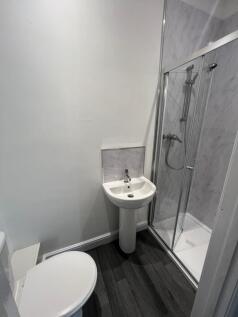 A modern bathroom featuring a sleek white pedes...