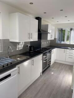 Bright and modern kitchen featuring sleek white...