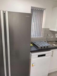 A modern kitchen featuring a tall silver fridge...