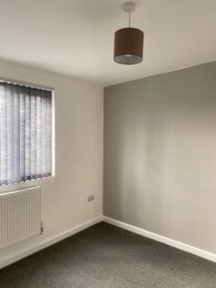 A clean and tidy single bedroom with neutral wa...