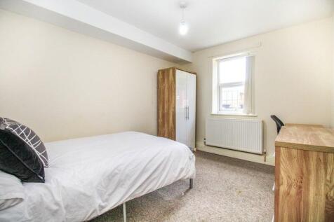 A bright single bedroom featuring a comfortable...