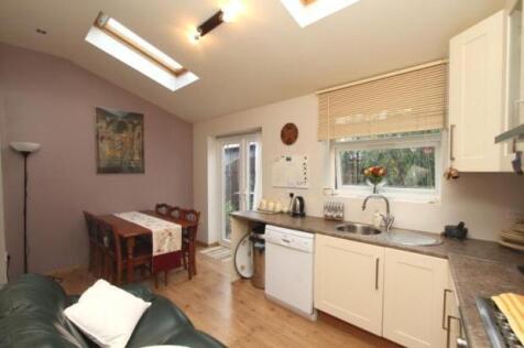 Bright and tidy kitchen featuring cream cabinet...