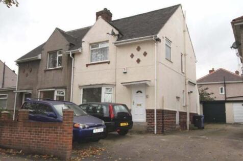 A semi-detached house with a driveway parking a...