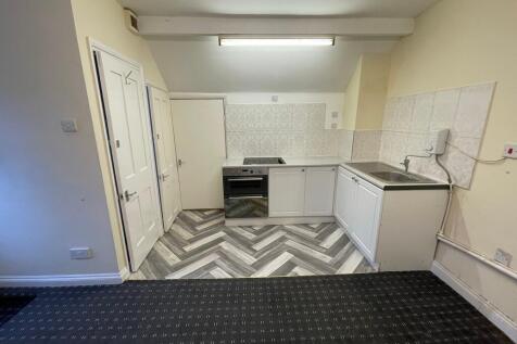 A compact kitchen area featuring modern herring...