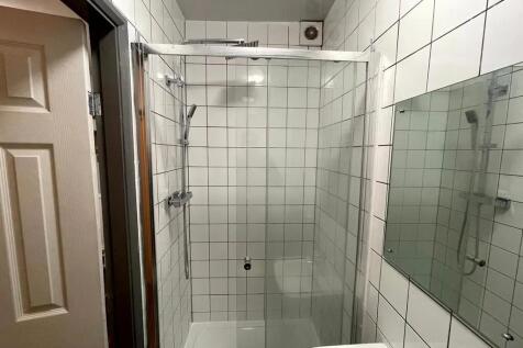 A modern, clean bathroom featuring white tiled ...