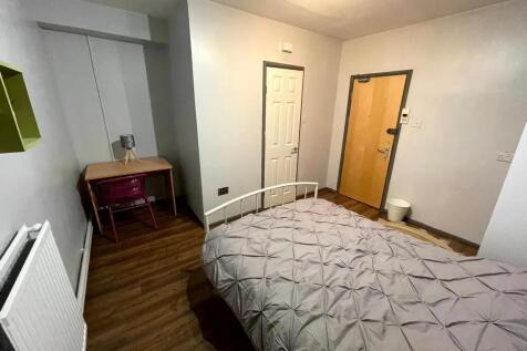 A neat and tidy single bedroom featuring a comf...