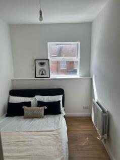 A cozy single bedroom featuring a comfortable b...